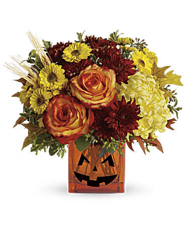 Halloween Glow - Happy Yellow-een! Yellow chrysanthemums are accented with bright orange roses -all finished with eucalyptus and autumn oak leaves. In an orange cube vase with a jack-o-lantern face, this is one bright and frightening boo-quet!