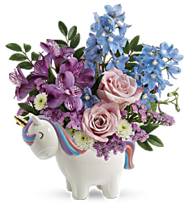 Bouquet of pink and blue flowers in a unicorn-shaped vase
