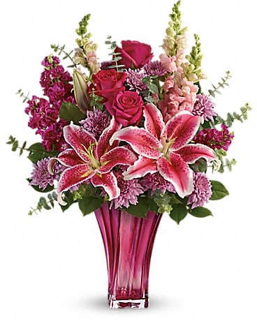 Teleflora's Bold Elegance Bouquet - When only the best will do for Mother's Day, surprise her with this incredible gift! Large and lush, this bouquet of hot pink roses, pink stargazer lilies and lavender mums is fragrant, feminine and fabulous. What an unforgettable treat when hand-delivered in this exquisite blown glass vase! This elegant bouquet features hot pink roses, pink stargazer lilies, burgundy stock, lavender cushion spray chrysanthemums, pink snapdragons, spiral eucalyptus, and lemon leaf. Delivered in a Bold Elegance vase.
