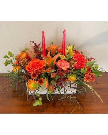 Autumn wishes - Table centerpiece, wooden coontainer, orange rose, zafron flower, daisy button mums and fillers and greenery. 2 taper candles to light dinner away. Container size 4"Â WÂ x 12"LÂ  Spread 12" W x 22"L x 15"H