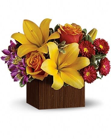 Yellow lilies and orange roses in a wooden cube vase