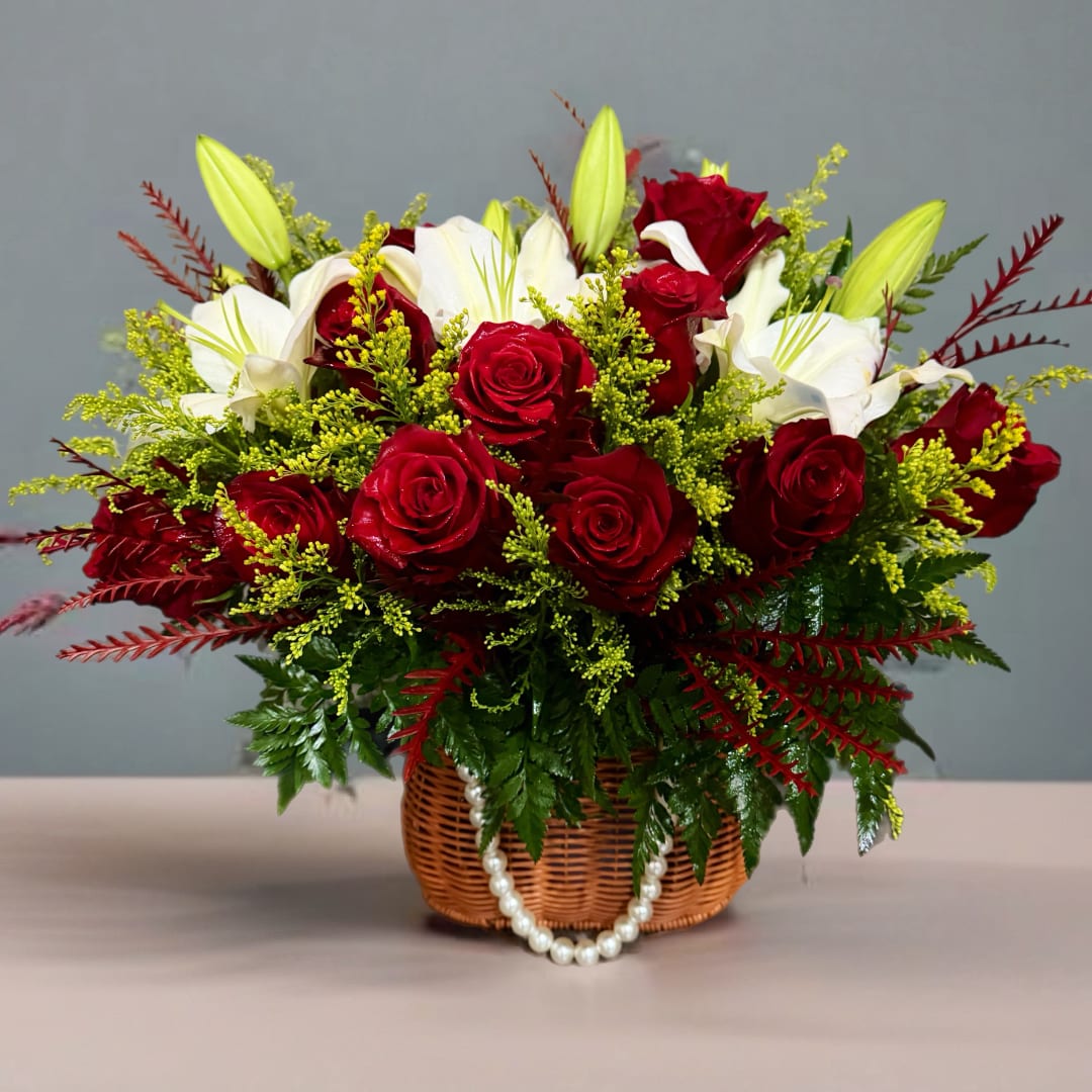 Basket arrangement of red roses and white lilies with pearl strands