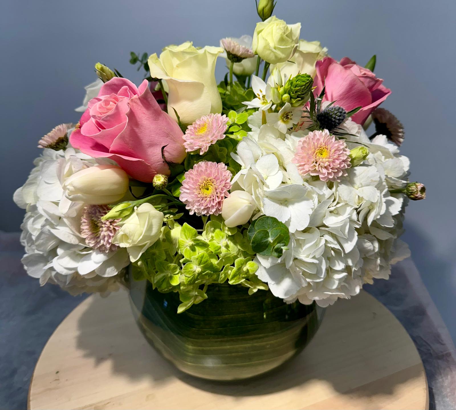 Pink and white roses with hydrangeas in a glass vase