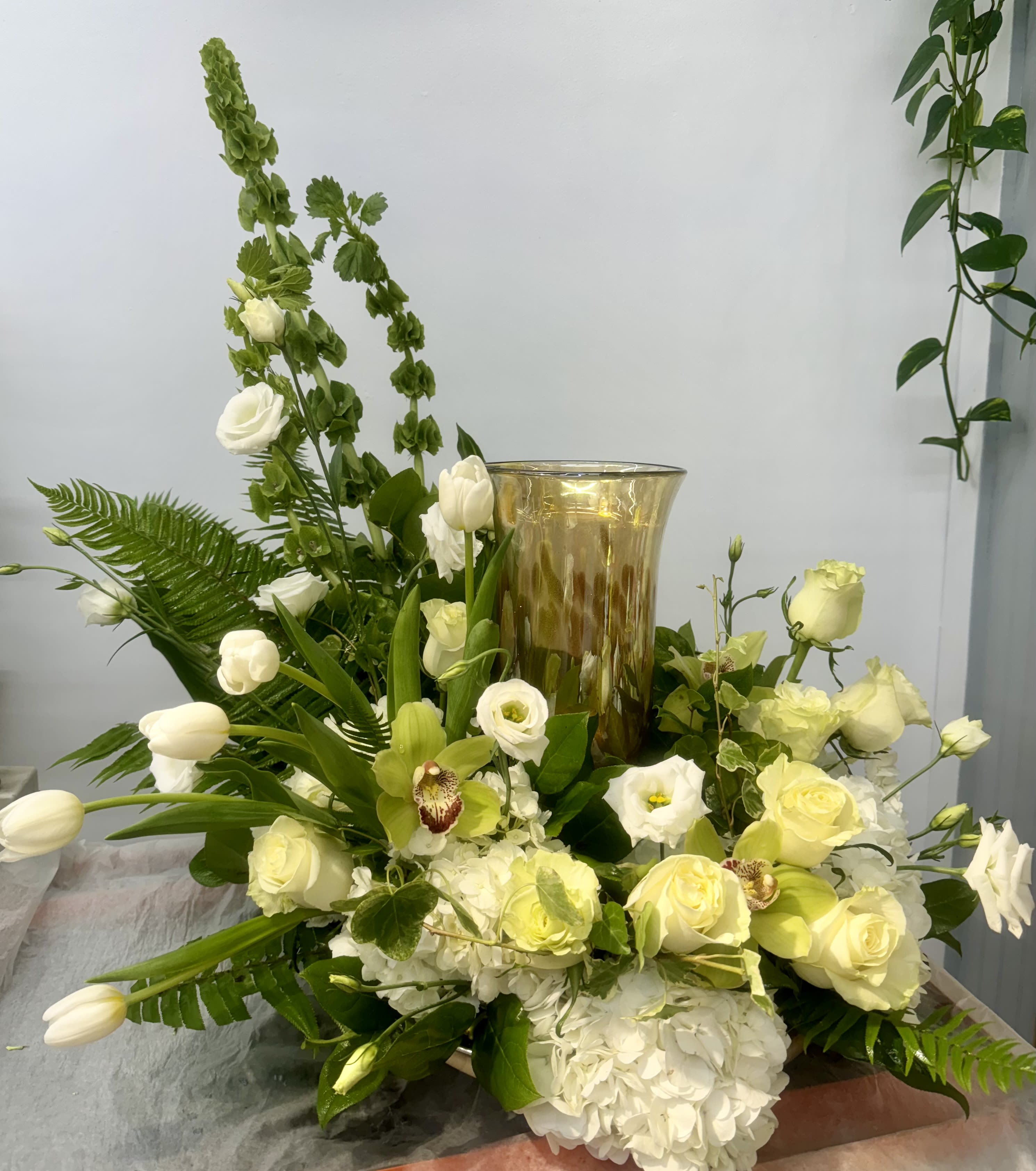 White and pale yellow floral arrangement with a gold vase centerpiece