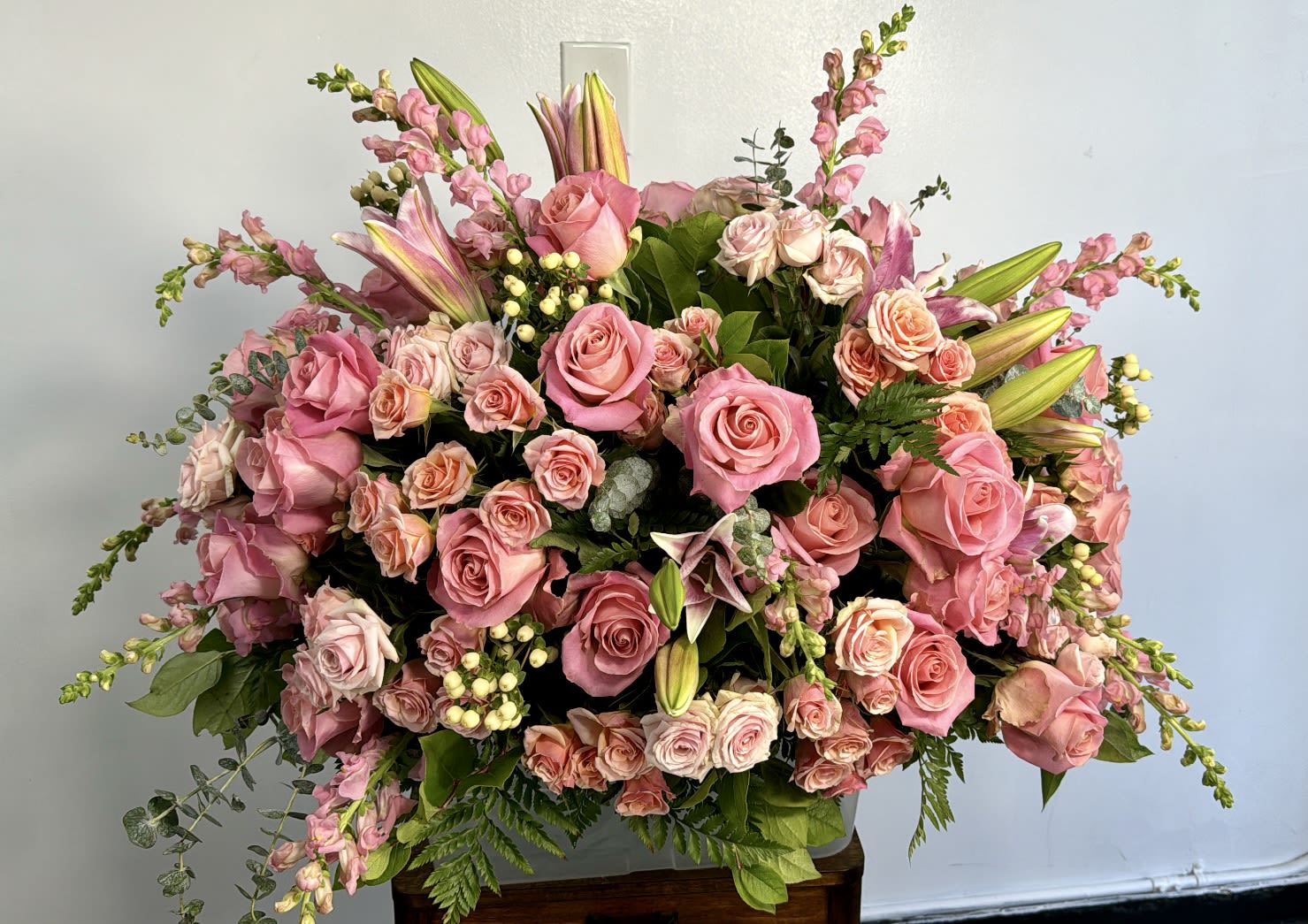 Large pink rose arrangement with lilies and snapdragons in a vase