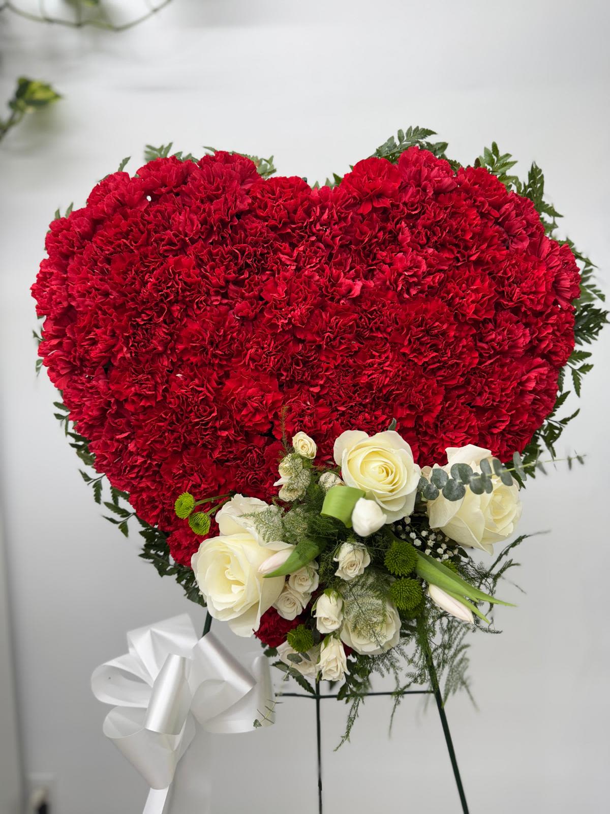 Heart-shaped red carnation arrangement with white roses and ribbon