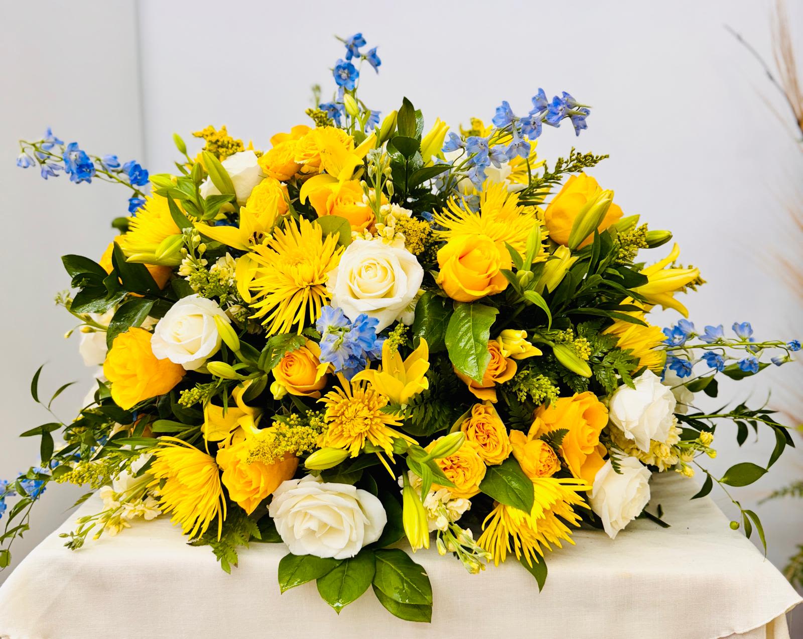 Yellow and white mixed flower arrangement with blue accents
