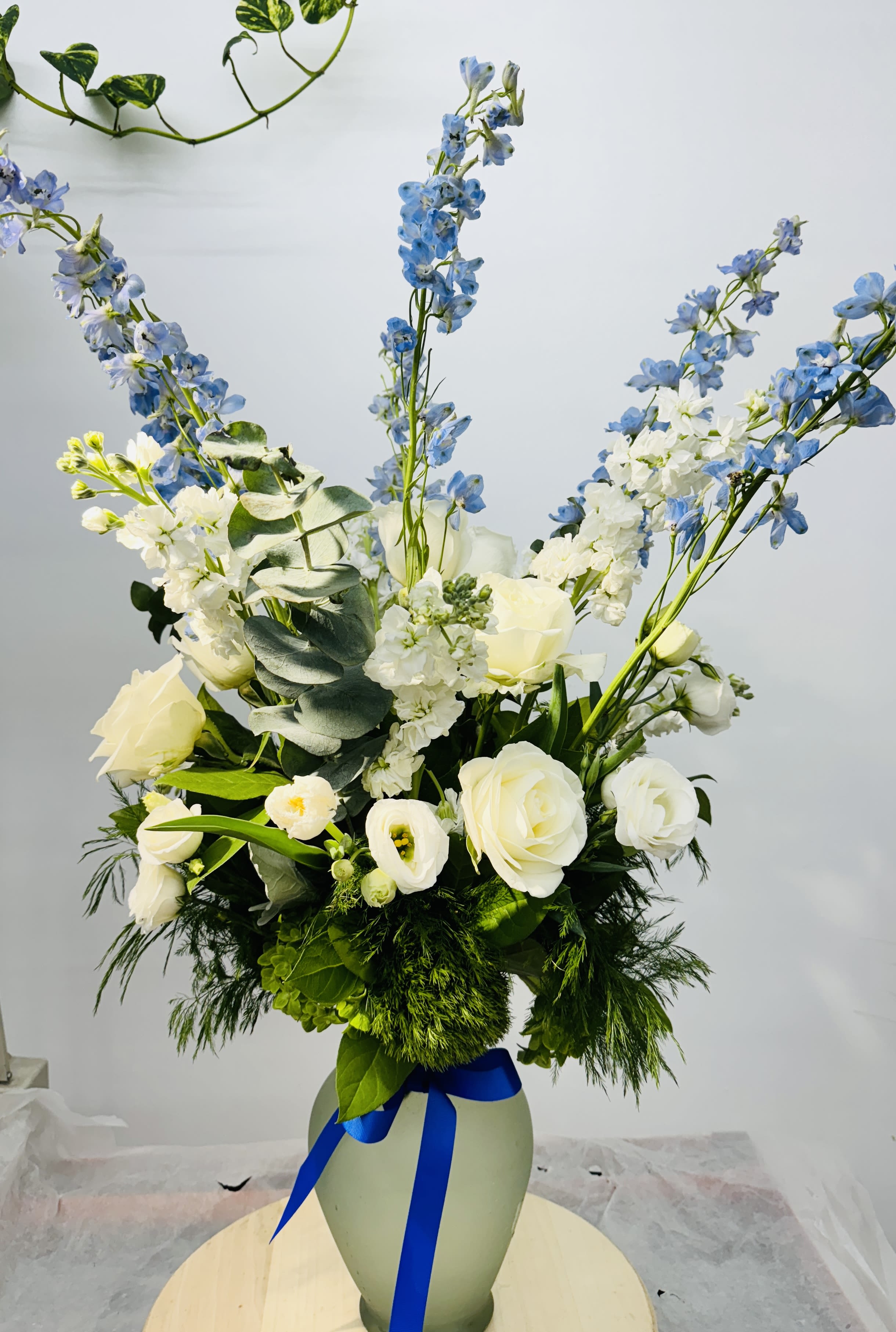 Orion's Belt by BloomNation™ - A blue and white arrangement featuring roses, tulips, and delphinium. Send this arrangement to anybody who likes stargazing or the night sky. A perfect gift to send for Hanukkah or the winter season.  Approximate Dimensions: 16"D x 28"H