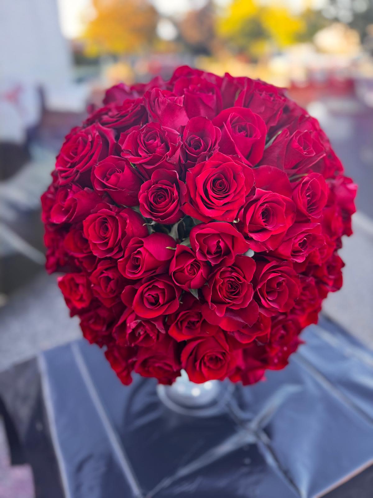 Round bouquet of red roses in a clear vase