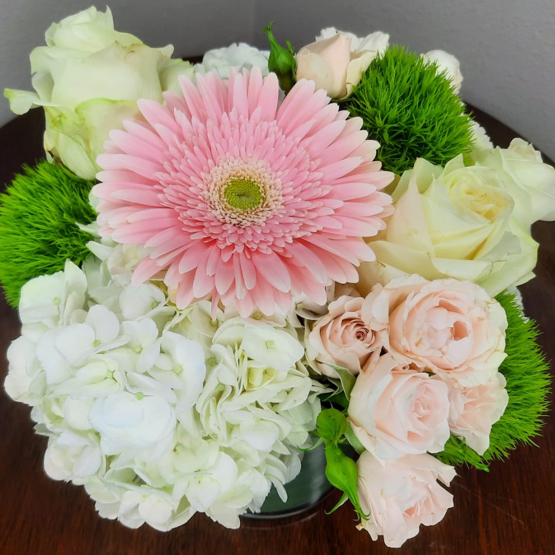 Pink gerbera daisy bouquet with white and blush roses in a vase