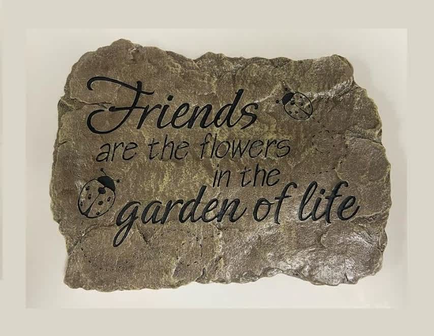 Decorative stone plaque with the quote "Friends are the flowers in the garden of life"