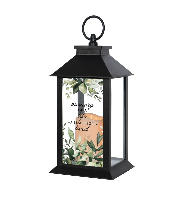 Black memorial lantern with leafy design and script text on the front panel