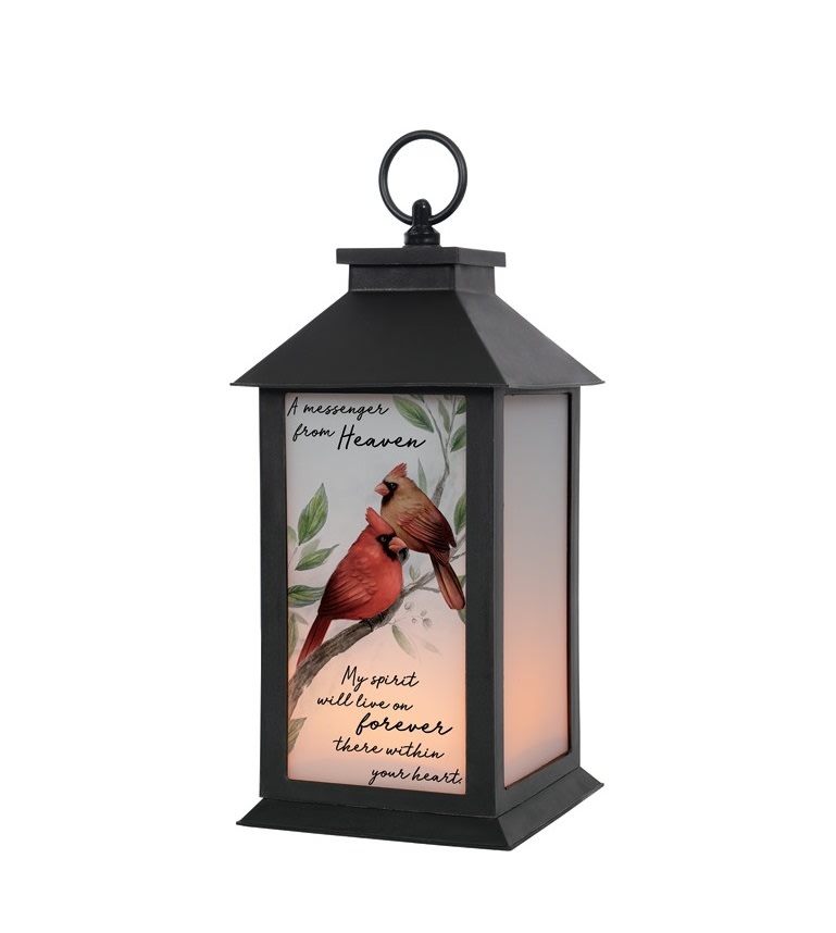 "A Messenger" Lantern - This lantern reads "A messenger from Heaven, my spirit will live on forever within your heart". These lanterns are made of weather friendly materials and UV printed glass. They are 12" tall and include a flameless LED candle with a built-in automatic timer: 6hrs ON/18hrs OFF. It can be purchased individually or with an accompanying floral arrangement (Deluxe).