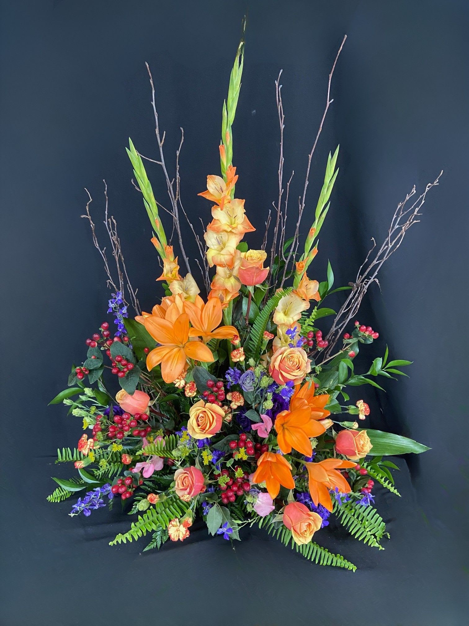 Tall floral arrangement with orange lilies and peach roses