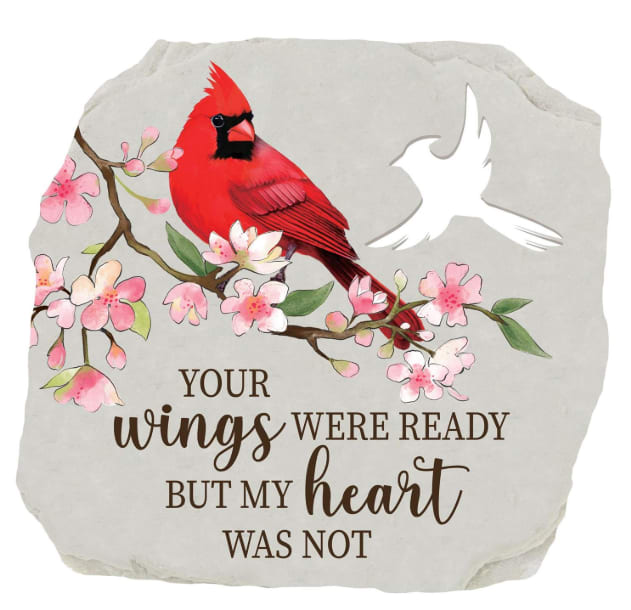 Decorative stone with a red cardinal, pink blossoms, and memorial text