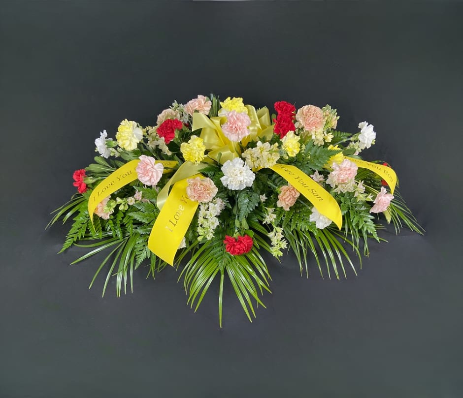 Sympathy floral spray with carnations and yellow ribbons