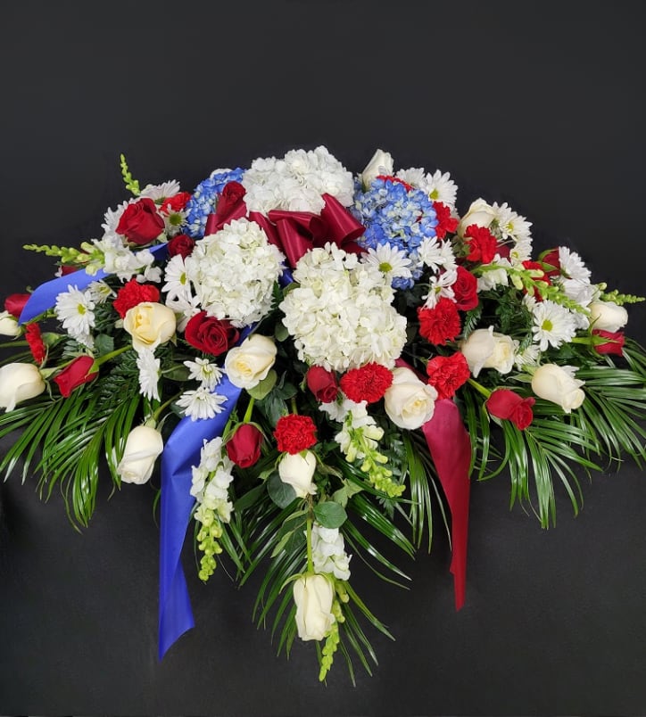 Large floral spray with red and white roses, hydrangeas, and daisies