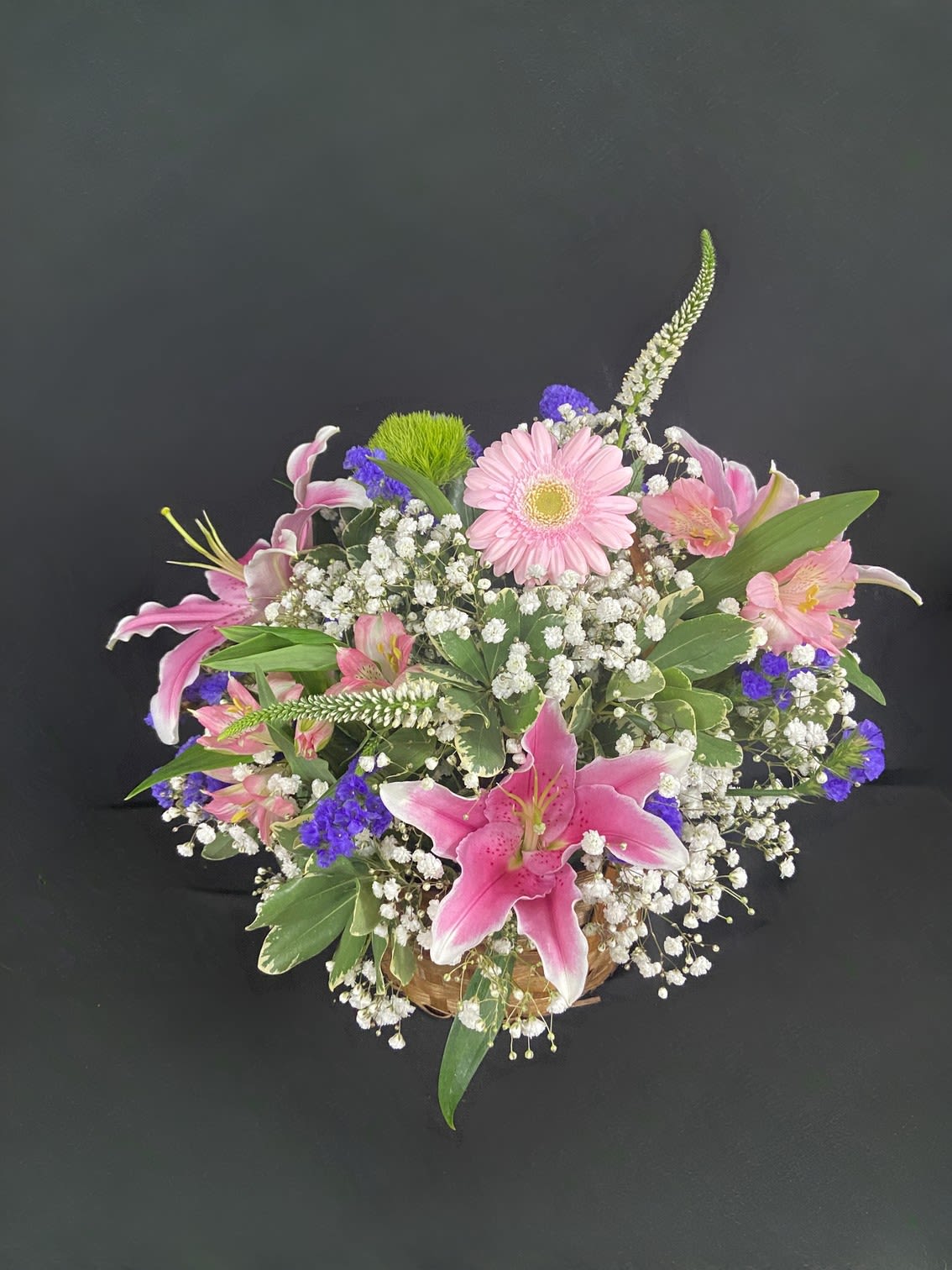 Garden Basket - A delightful basket filled with fragrant flowers including Stargazer Lilies, Alstroemeria, Gerbera Daisies, Statice, Spider Anastasia, and Baby's Breath.
