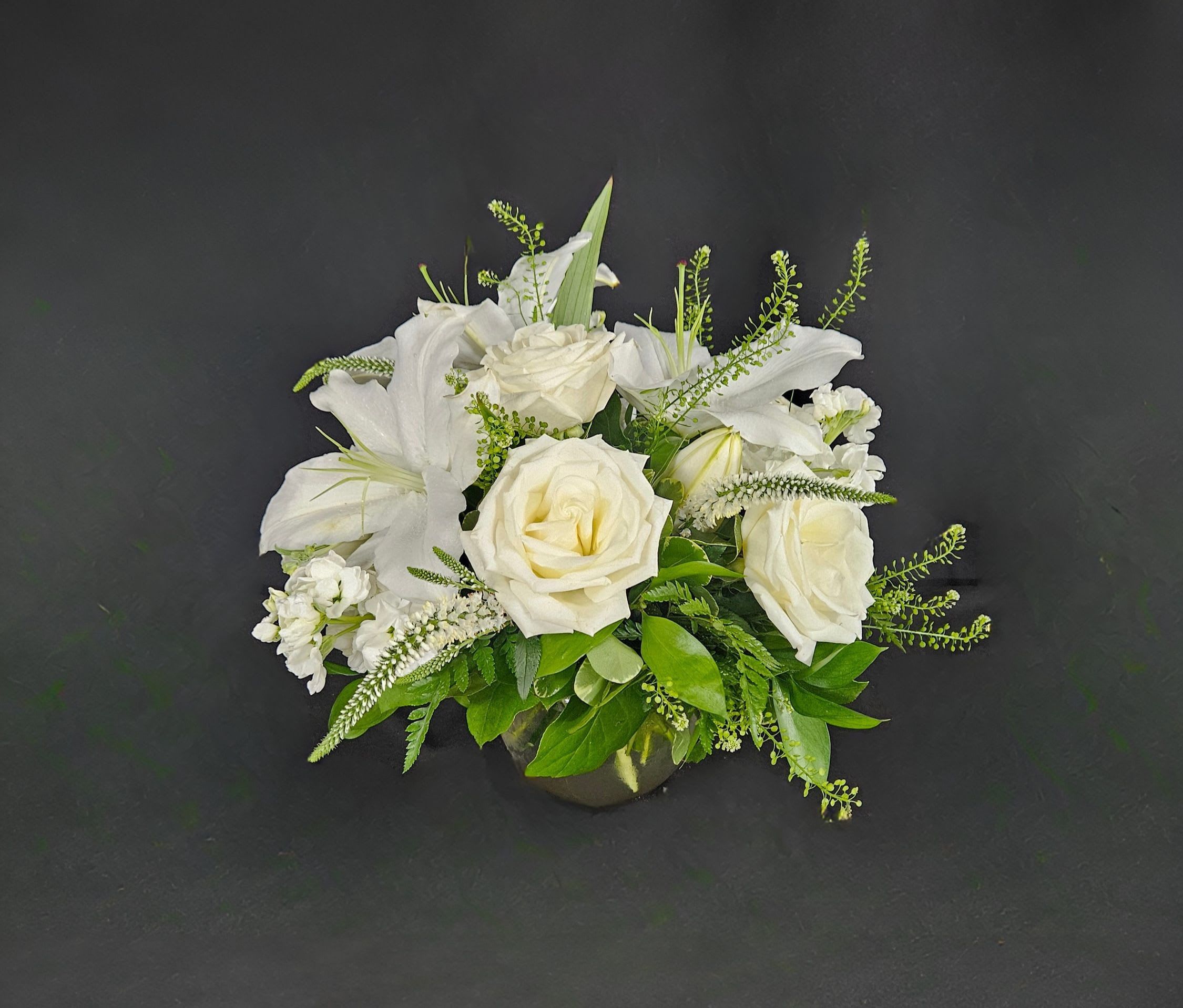 Sweet Thoughts - This arrangement includes white roses, white lilies, white stock, and dusty miller. Send your condolences with Sweet Thoughts by BloomNation™. 