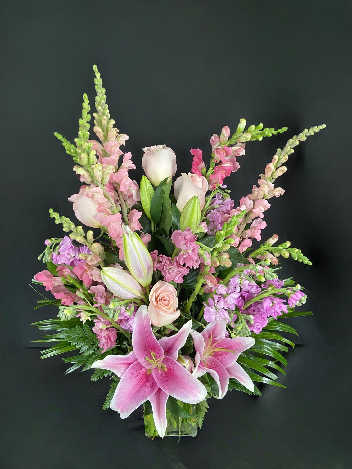 Amethyst Magic  - Amethysts can come in a variety of beautiful purple colors just like this one-sided arrangement. Featuring stargazer lilies, tulips (seasonal) or roses, stock and snapdragons, this arrangement makes a beautiful birthday present or a lovely congratulations gift.