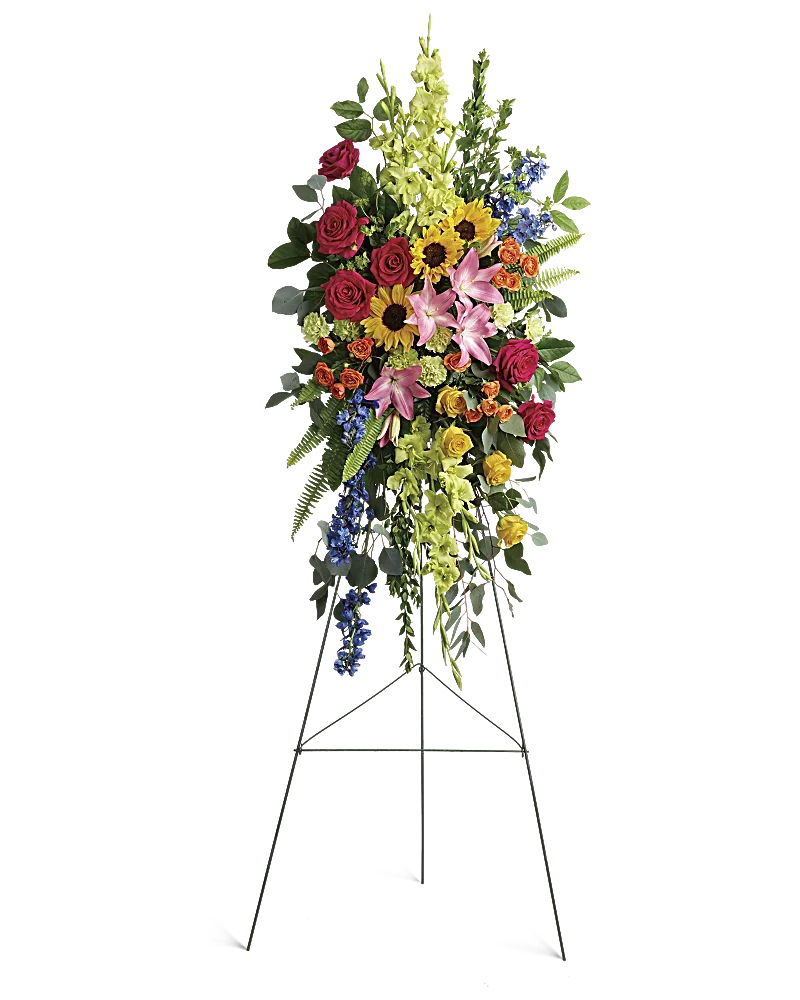 Standing floral spray with roses, lilies, sunflowers, and blue delphinium