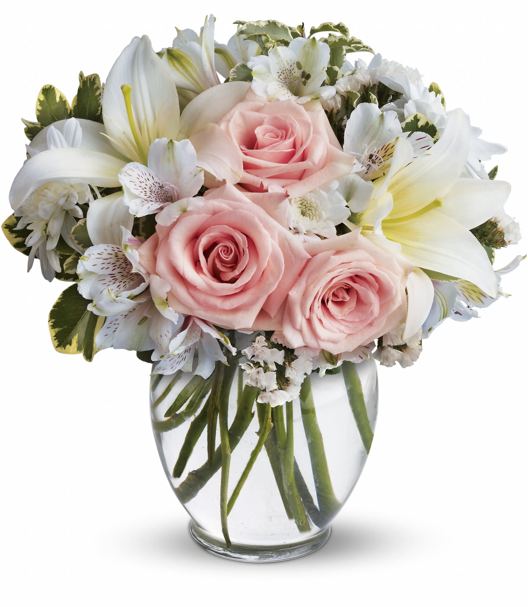 Pink roses and white lilies arranged in a clear glass vase