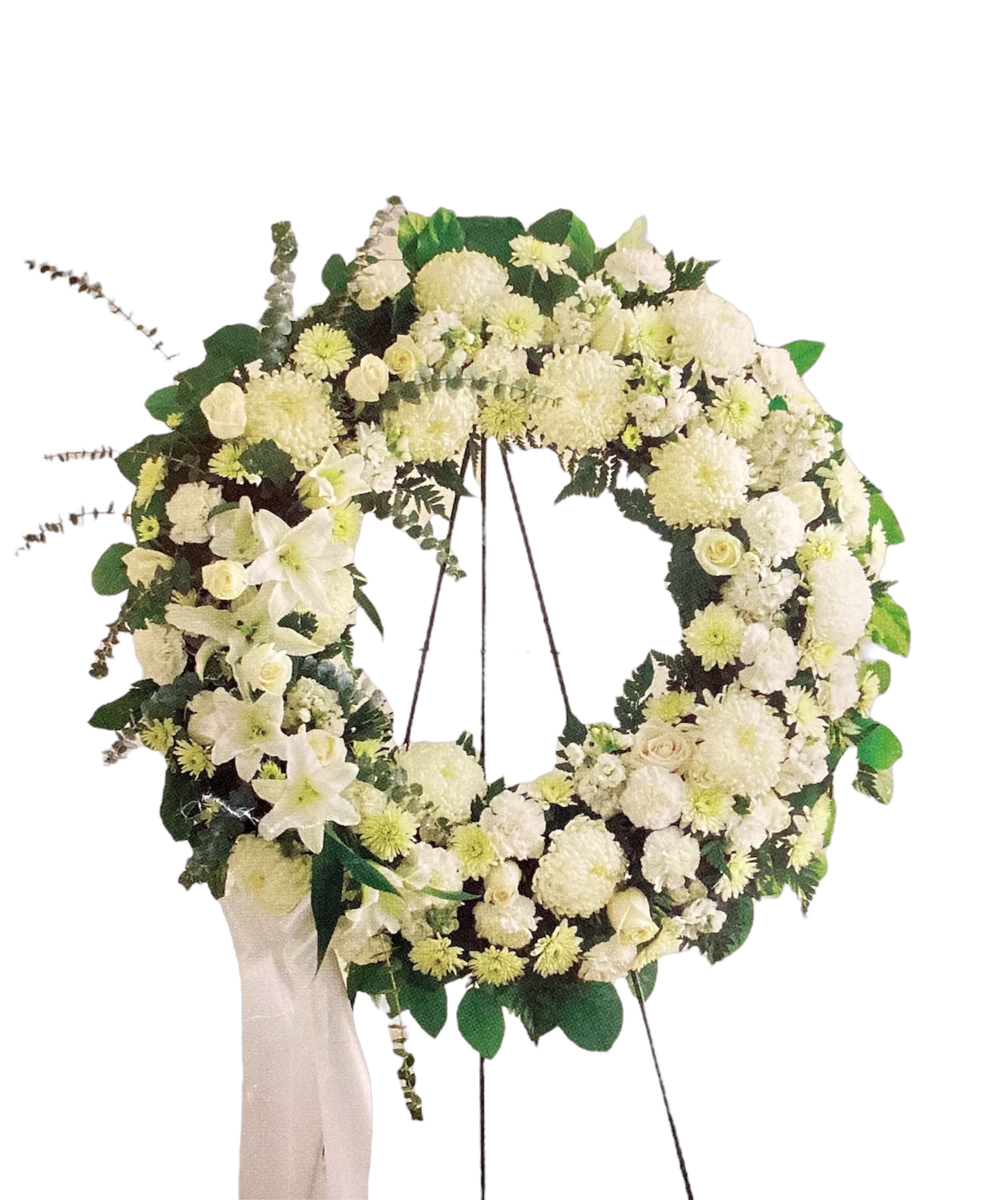 White floral wreath on an easel with a ribbon drape