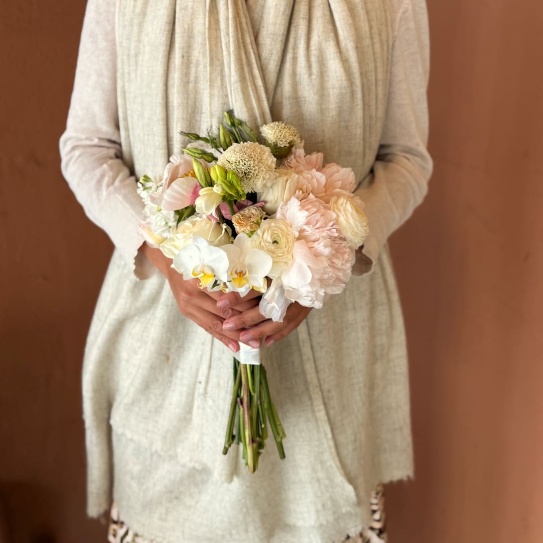 Bride holding a pastel bouquet of white and blush flowers