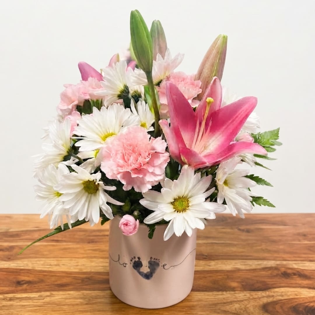 Pink lilies and white daisies in a blush ceramic vase