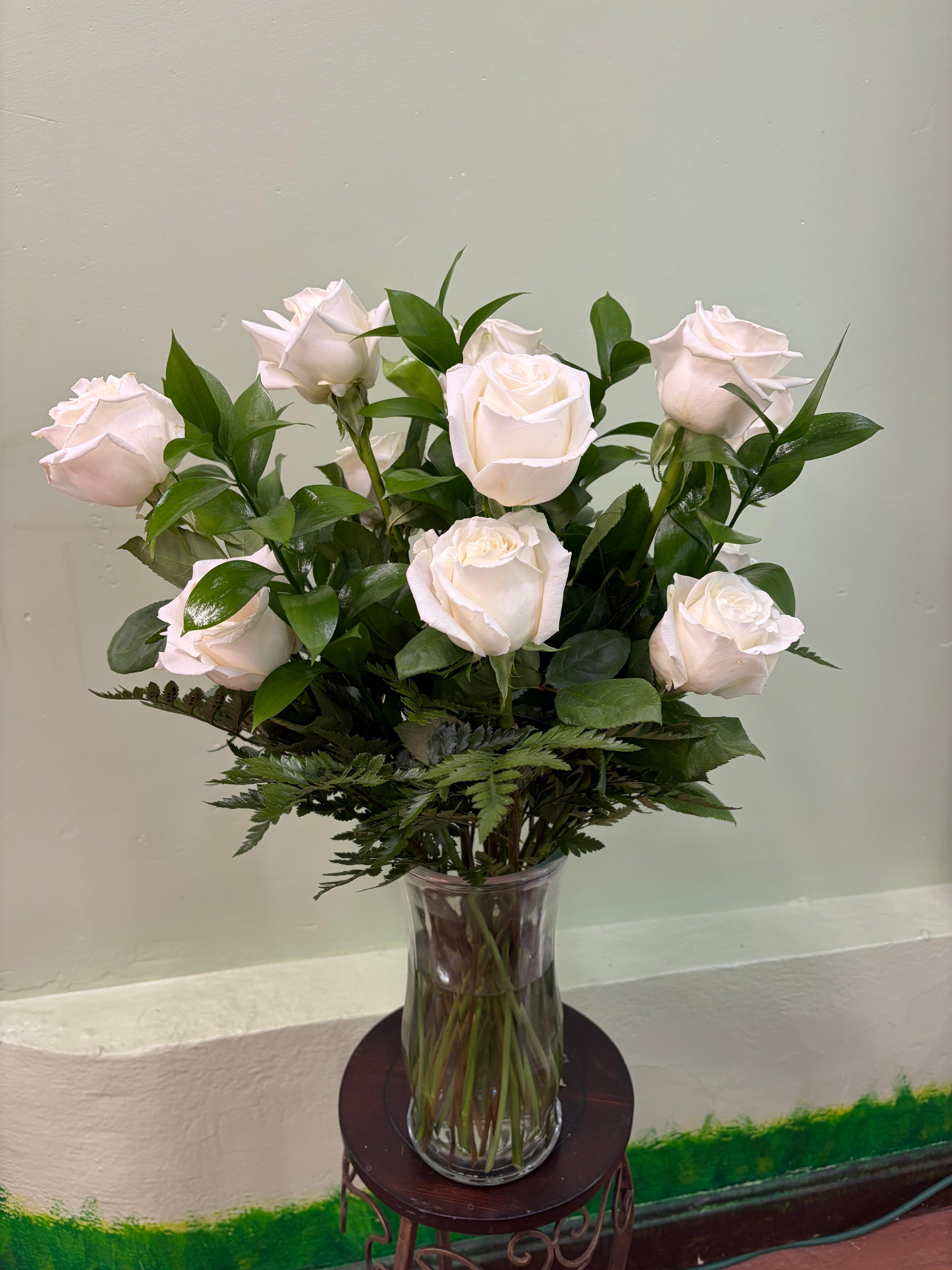 Blush Serenity Roses - A classic arrangement of soft blush roses beautifully arranged in a clear glass vase, surrounded by rich greenery and delicate fern accents. This timeless design offers a gentle, romantic feel—perfect for expressing love, appreciation, or simply brightening someone’s day with natural beauty.