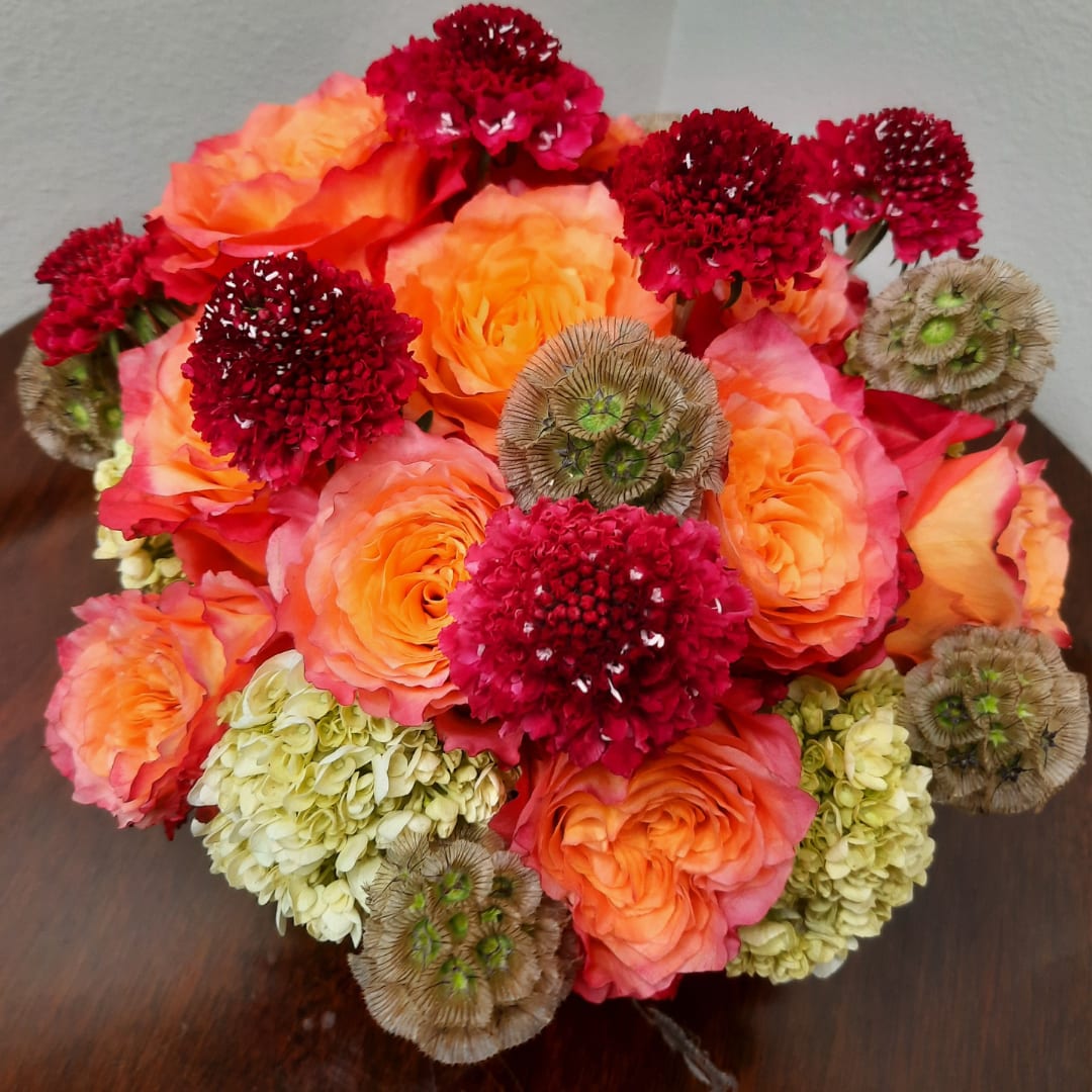Bouquet of orange roses with red and pale green accent flowers