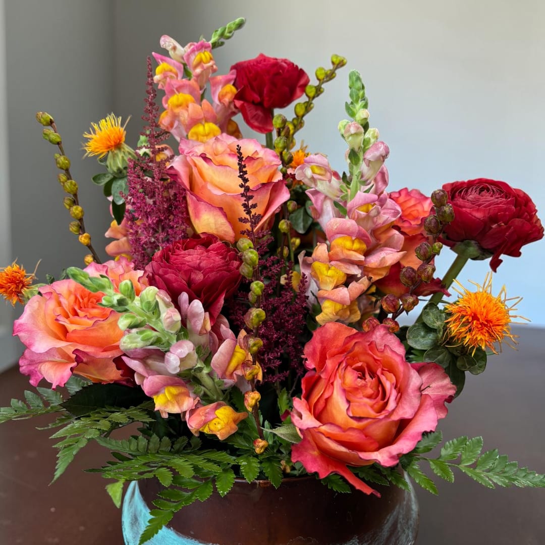 Mixed bouquet of pink and orange roses with snapdragons in a vase