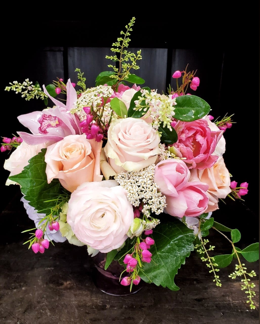 Pink and peach rose bouquet with orchids in a vase