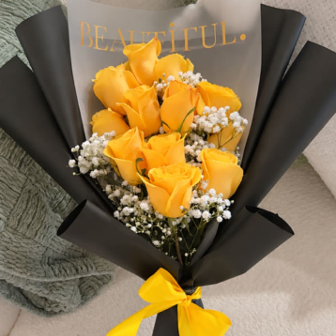 Bouquet of yellow roses wrapped in black paper with a yellow ribbon