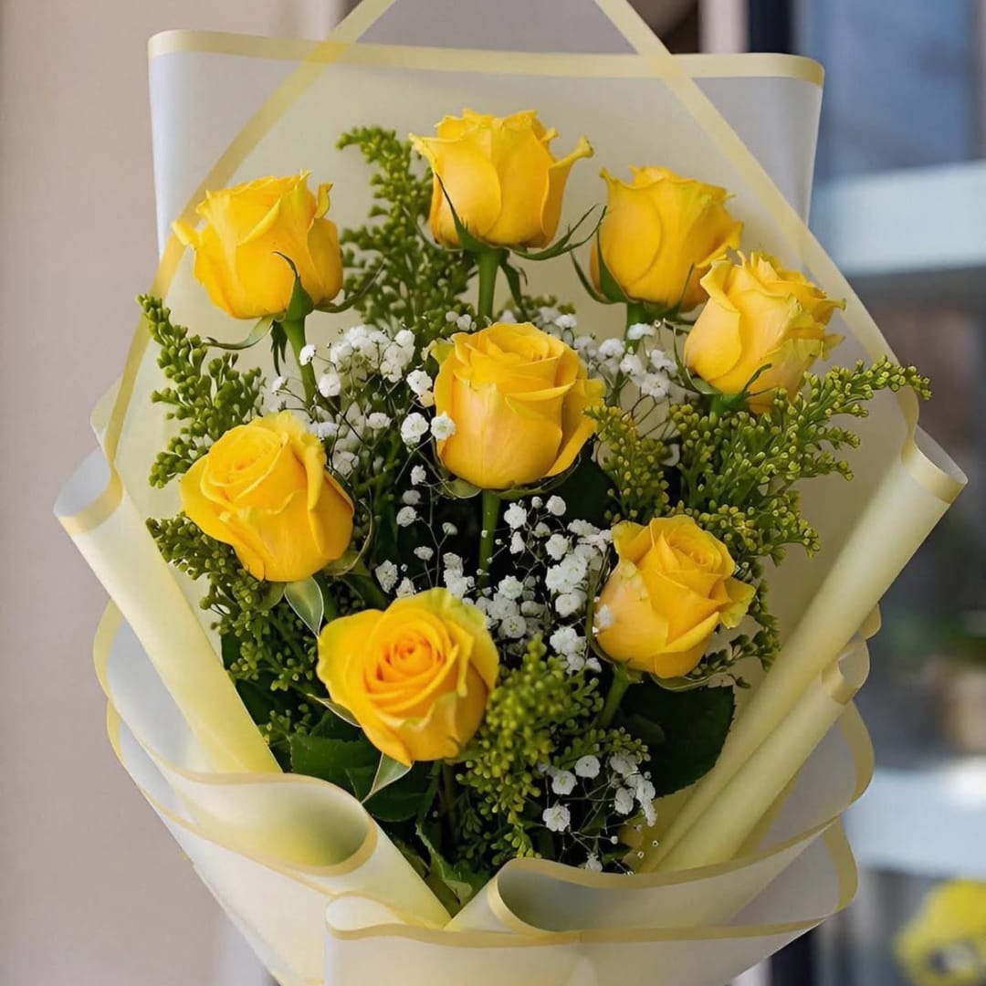 Bouquet of yellow roses with white baby's breath in pale wrapping