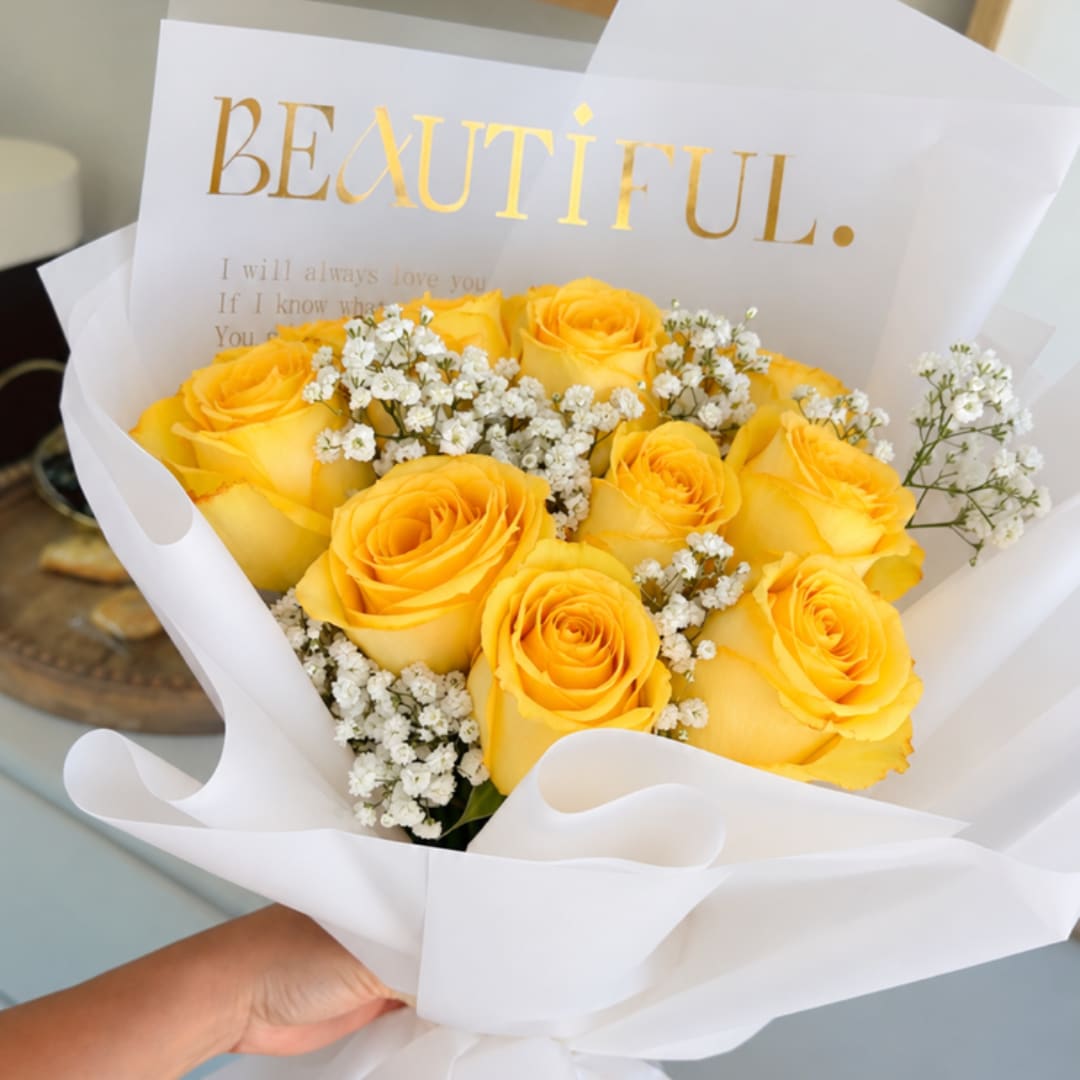 Yellow roses with white baby's breath in white wrapping
