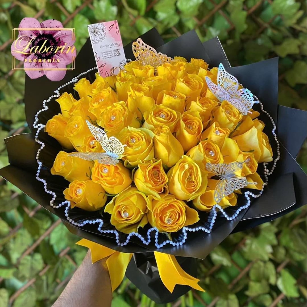 Bouquet of yellow roses wrapped in black paper with butterfly picks