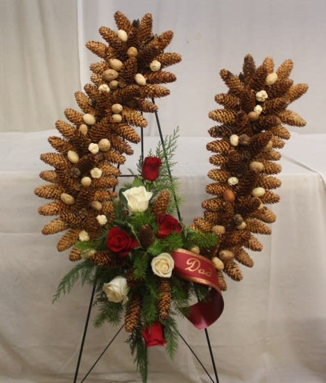 Pinecone wreath with red and white roses on a stand