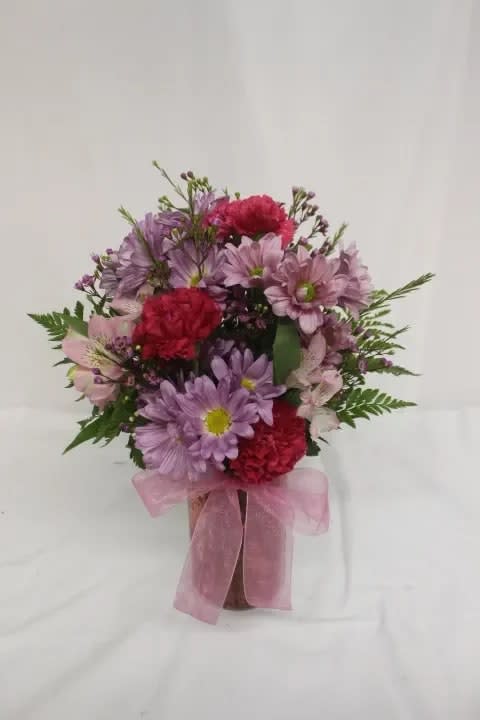 Pink and purple mixed bouquet in a vase with a pink ribbon