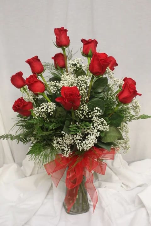 Bouquet of red roses with baby's breath in a glass vase