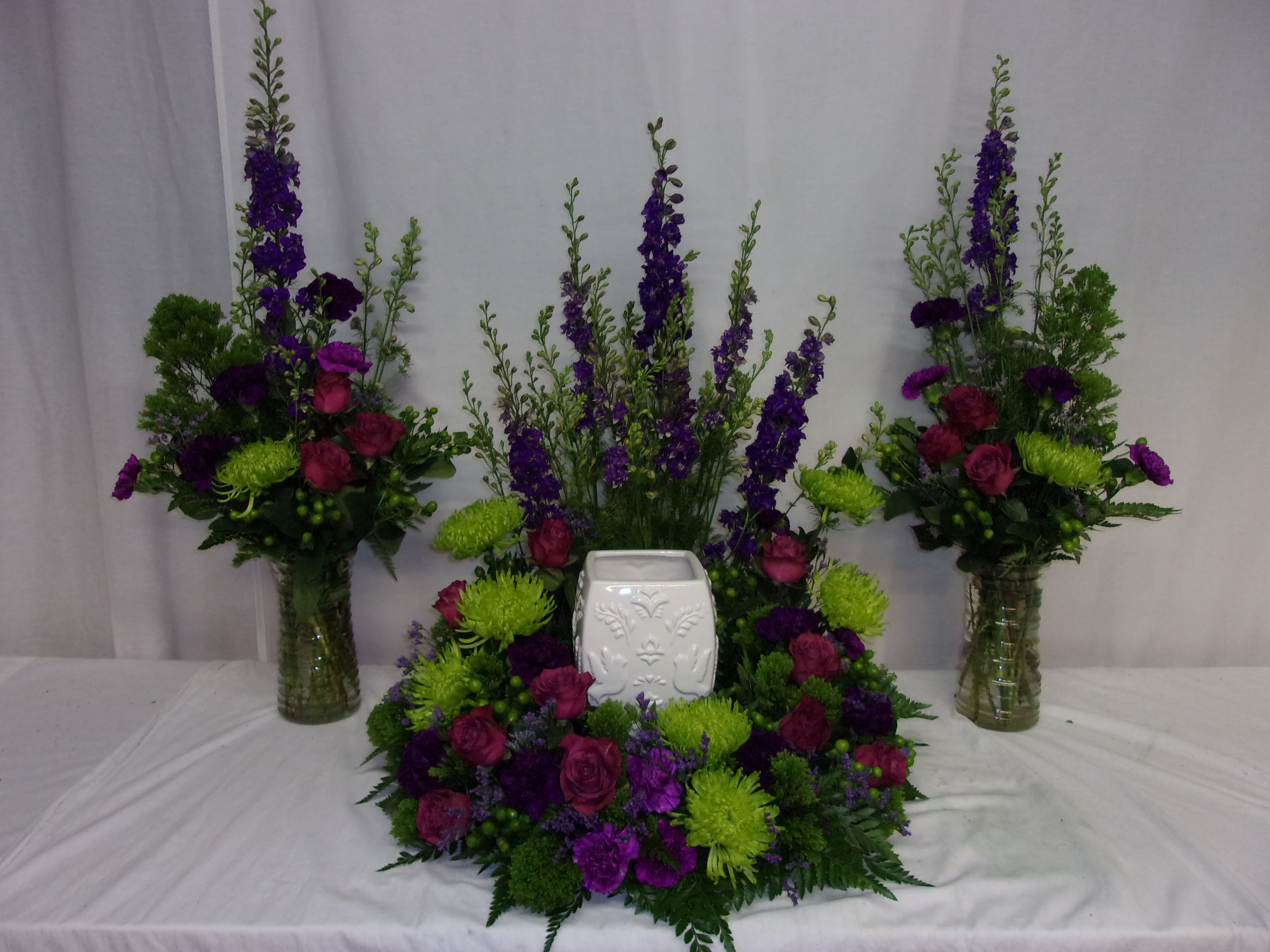 Purple and green floral funeral set with a white urn in the center