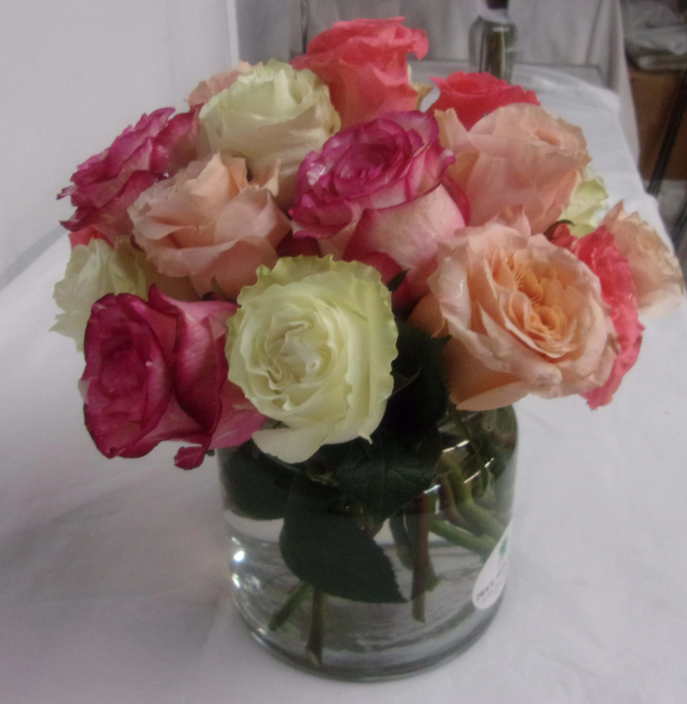 Bouquet of multicolored roses in a clear glass vase