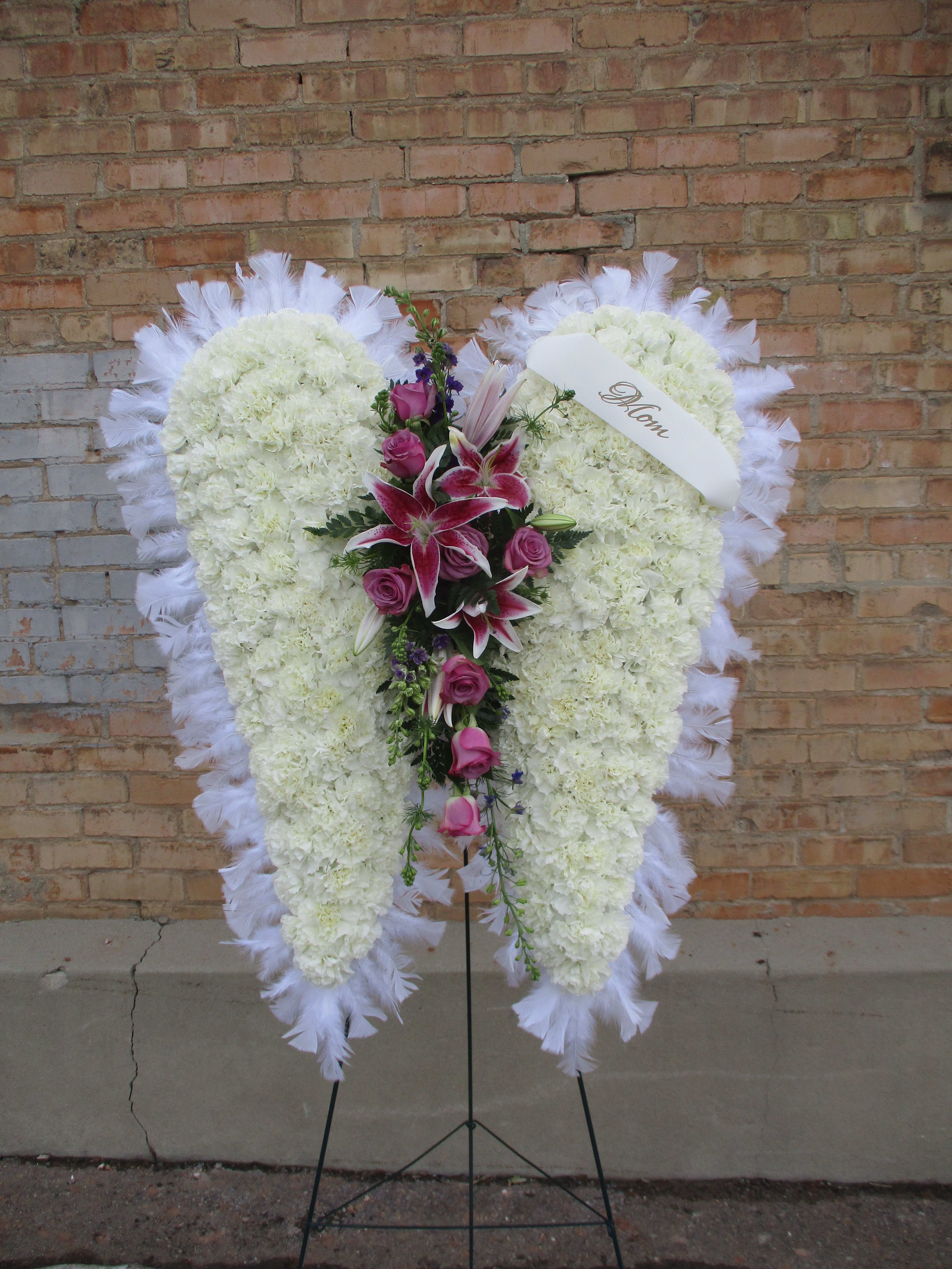Heart-shaped white floral standing spray with pink lilies and roses