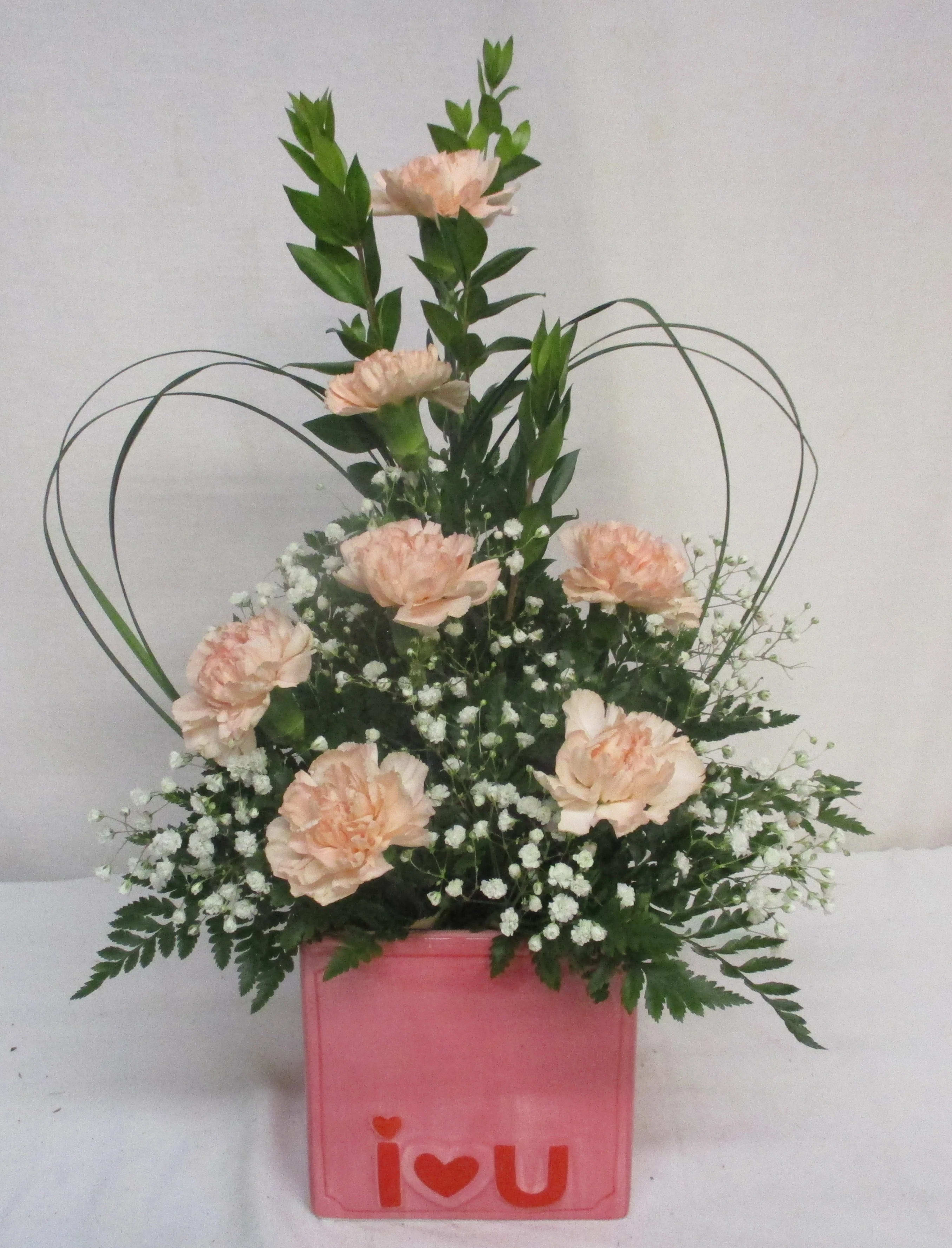 Peach carnations in a pink box with white filler flowers
