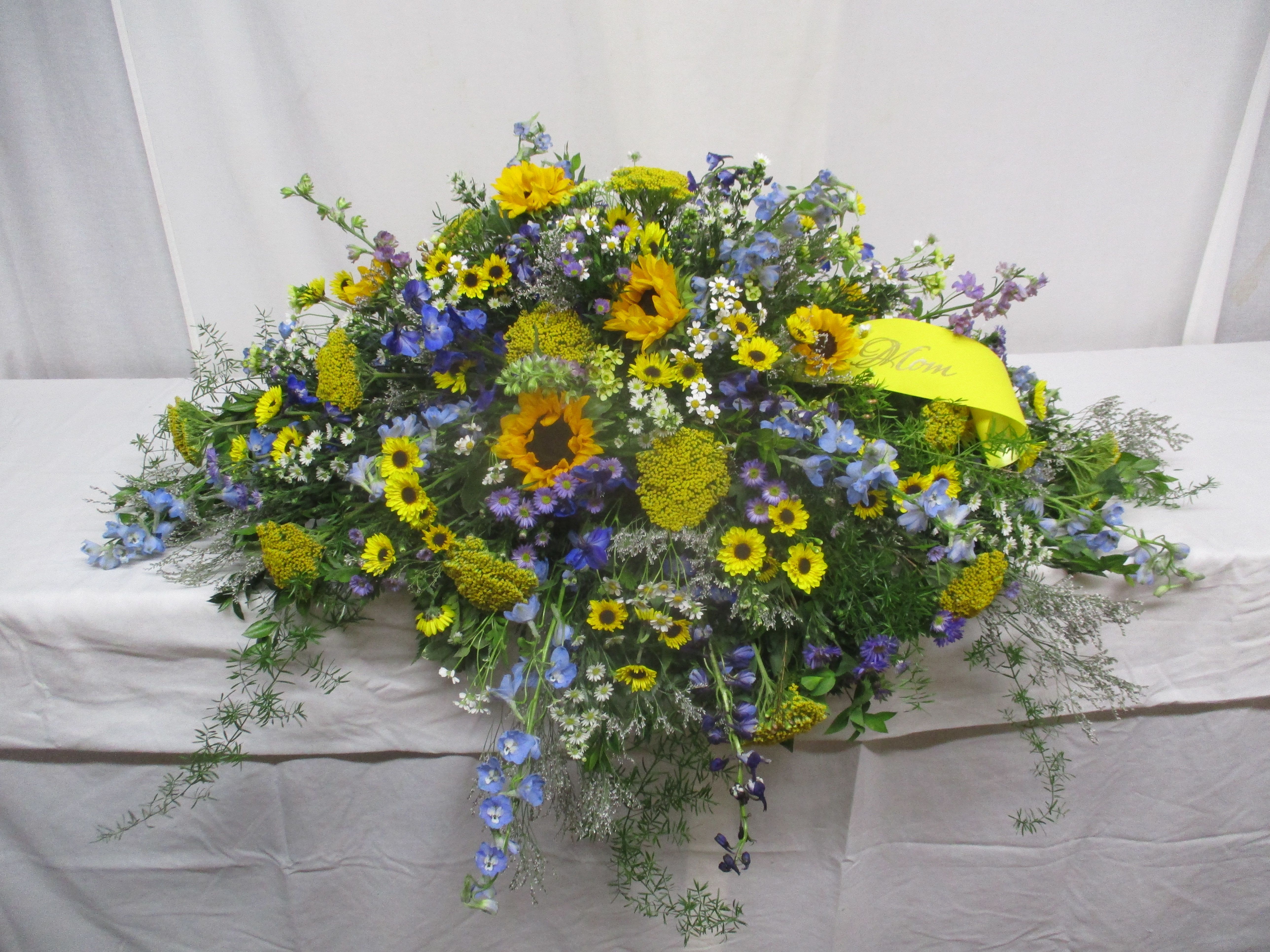 Large mixed floral spray with yellow and blue flowers on a table