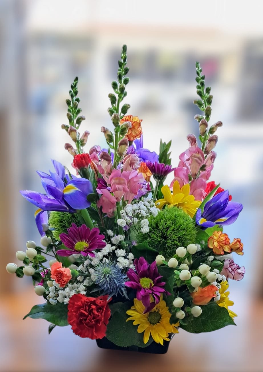 Colorful mixed bouquet in a black container with tall blooms
