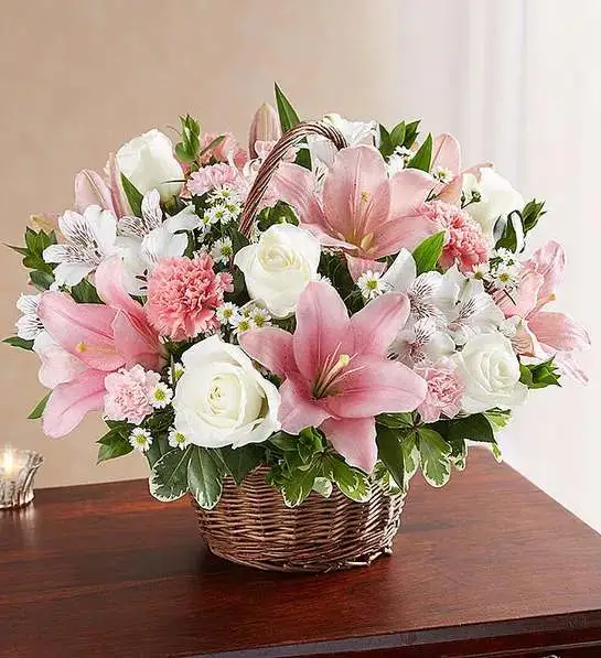 Peac &amp; Blessings   Pink &amp; White basket  - Representing care, compassion and love - pink blooms can offer solace in times of sorrow. Artistically designed inside a keepsake willow basket, our arrangement in soothing pink hues is a touching way to offer your sincerest blessings.  white roses, alstroemeria and monte casino and pink Asiatic lilies, carnations and mini carnations; accented with fresh greenery