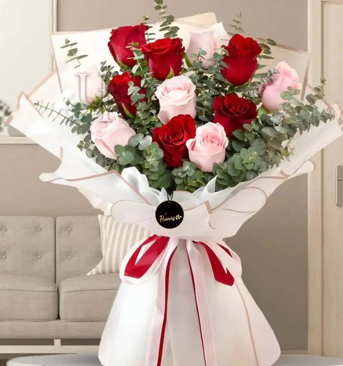 Bouquet of red and pale pink roses wrapped in white paper