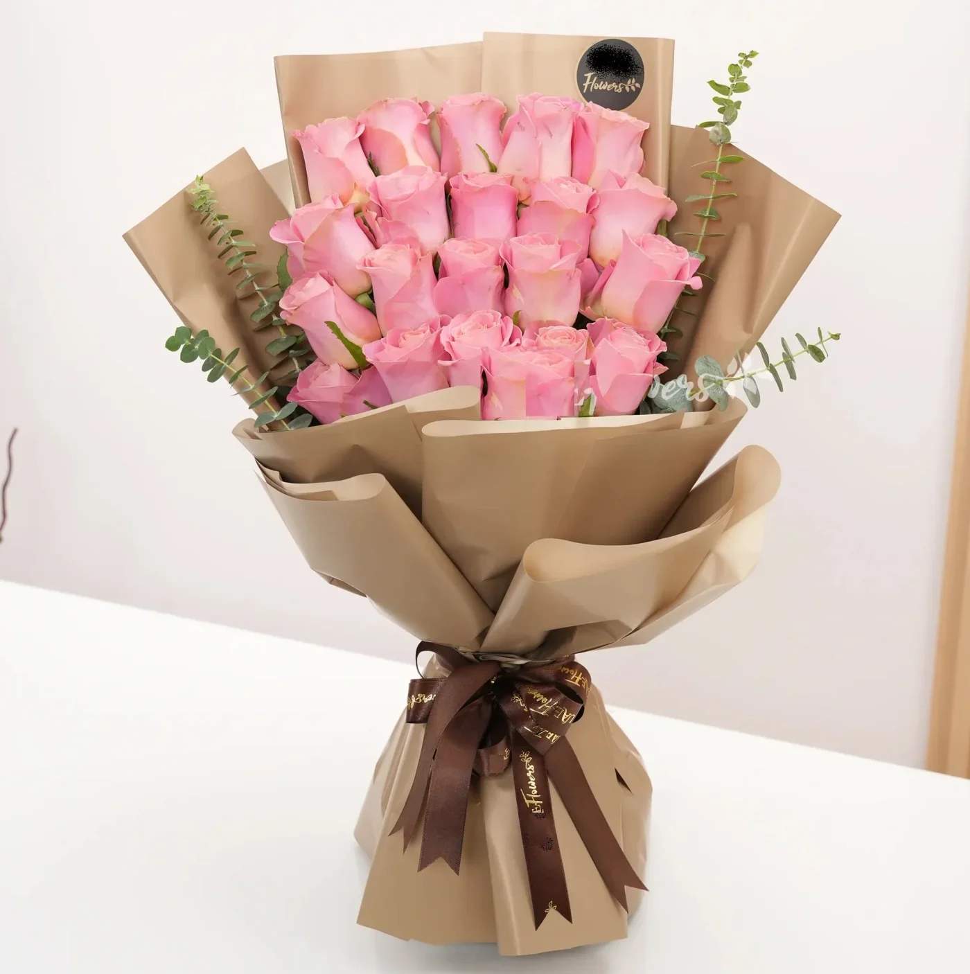 Bouquet of pink roses wrapped in brown paper with a ribbon