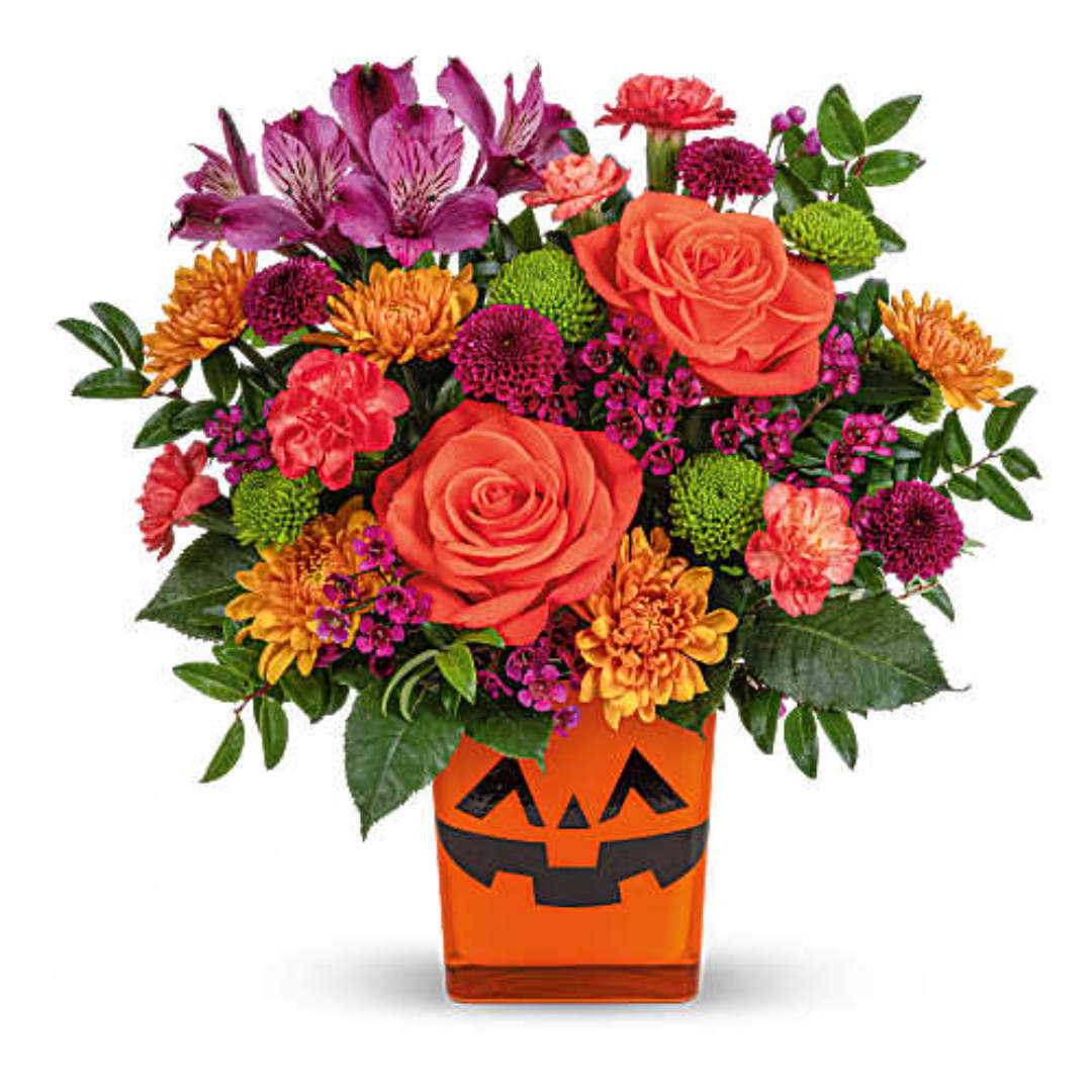 Bouquet of orange and purple flowers in a jack-o'-lantern vase